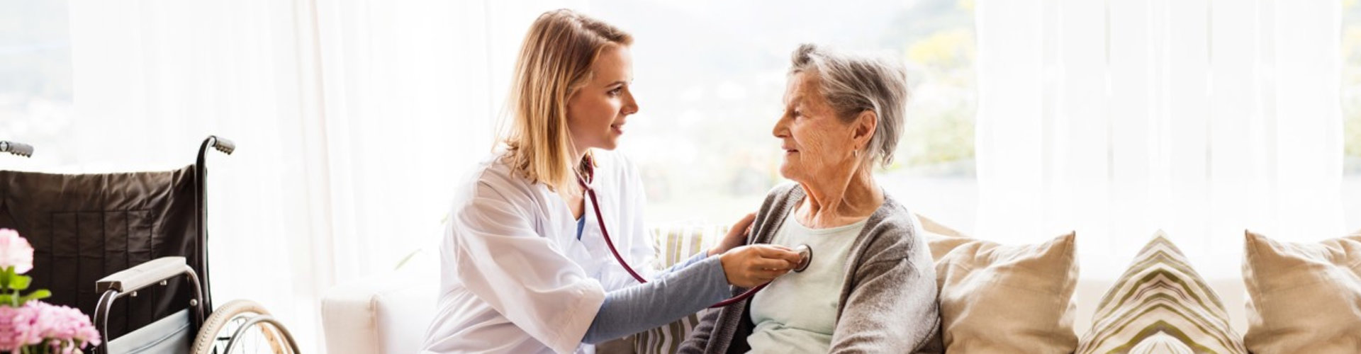 caregiver checking up an elderly woman
